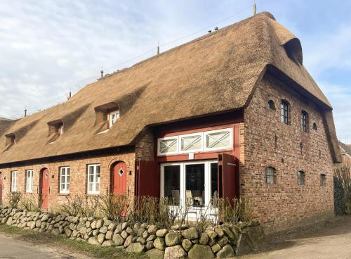 a thatch roofed house with a thatched roof at Foftein in Borgsum