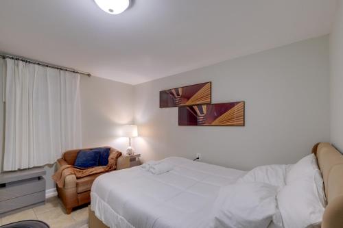 a bedroom with a white bed and a chair at Work & Explore, Cozy Unit 5 Mi to UMD! in Lanham