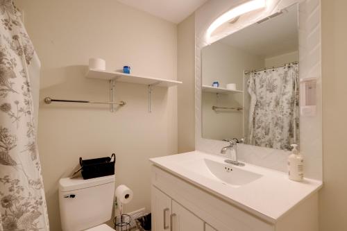 a bathroom with a sink and a toilet and a mirror at Great for Gatherings! Modern Lanham Duplex in Lanham