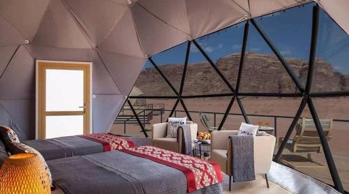 een kamer met drie bedden in een tent bij Desert Stars Bubble Camp Wadi Rum in Wadi Rum