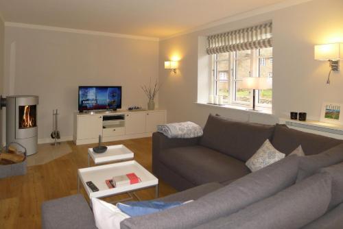 a living room with a couch and a tv at Simons Hüs in Oldsum