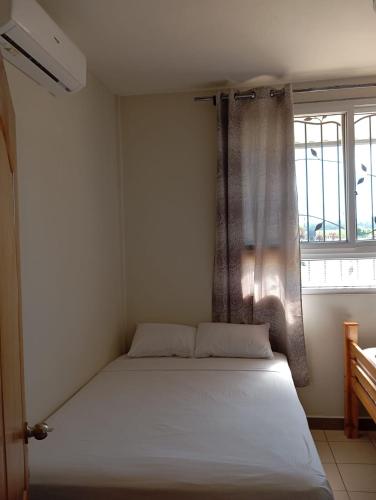 un letto in una stanza con una finestra di Casa Miranda - Retalhuleu a Retalhuleu