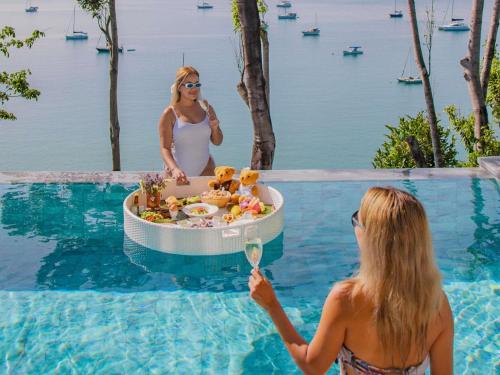 two women standing in a swimming pool with a drink at V Villas Phuket - MGallery Collection in Panwa Beach