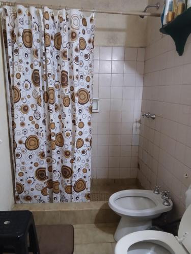 a bathroom with a toilet and a shower curtain at Las Gemelas in Rosario