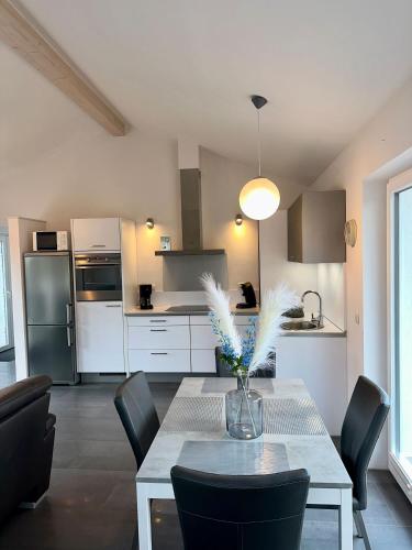 a kitchen with a table with a vase of feathers on it at Ferienhaus Schlossblick - ABC236 in Zierow