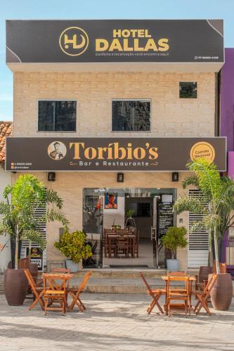 a hotel with tables and chairs in front of a building at Hotel Dallas Toríbio in Bom Jesus da Lapa