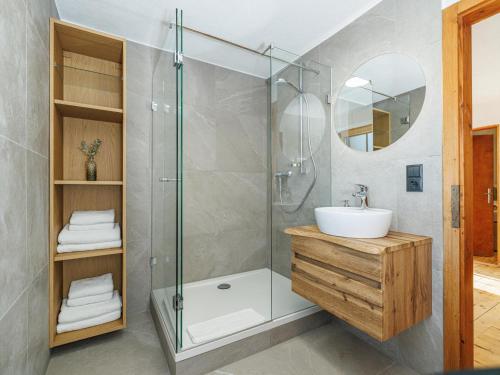 a bathroom with a shower and a sink and a mirror at Tirola Hütte in Alpbach