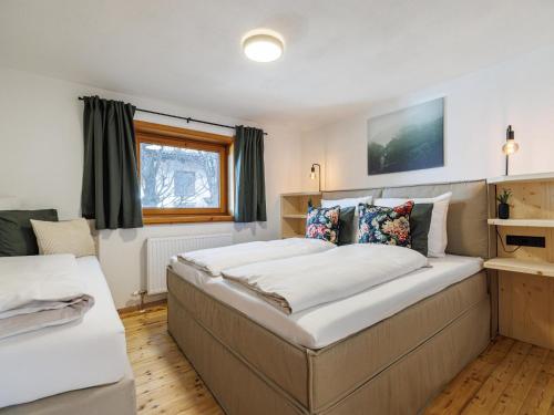 a bedroom with two beds and a window at Tirola Hütte in Alpbach