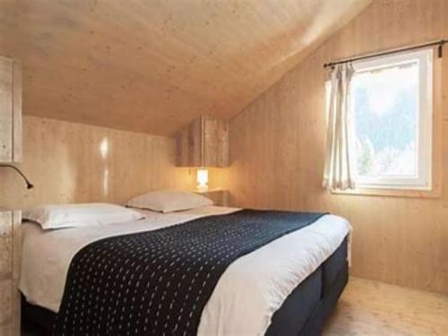 een slaapkamer met een groot bed en een raam bij De Berghut in Stadl an der Mur