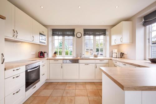 una cucina con mobili e ripiani bianchi e finestre di Haus Seefahrer 1 a Goting