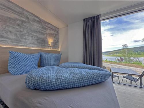 ein Schlafzimmer mit einem Bett und einem großen Fenster in der Unterkunft Feriendorf Seeblick - Tiny Chalet Nr 10 in Neunburg vorm Wald