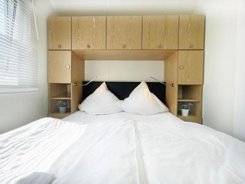 a large white bed with two pillows on it at Strandhaus James Cook Teichhof Fehmarn in Wenkendorf
