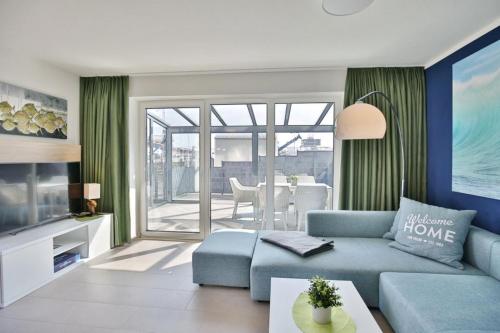 a living room with a blue couch and a table at City Marina, CM16c in Cuxhaven