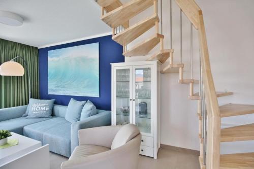 a living room with a blue couch and a staircase at City Marina, CM16c in Cuxhaven