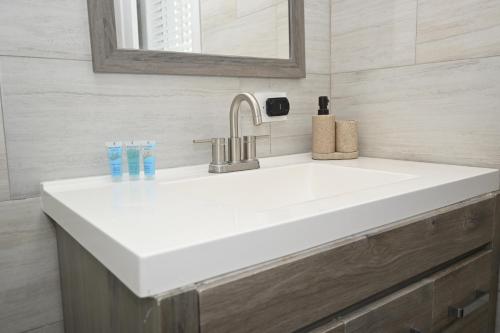 a white sink in a bathroom with a mirror at Sunsetville in Savannah Sound