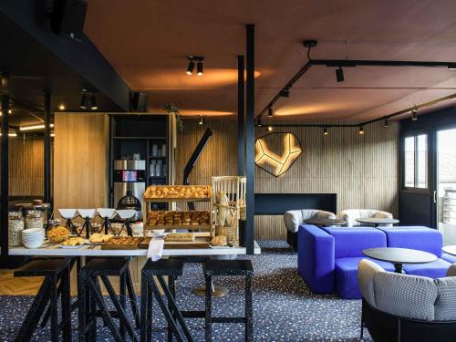 a room with a table and chairs and a couch at Tribe Carcassonne in Carcassonne