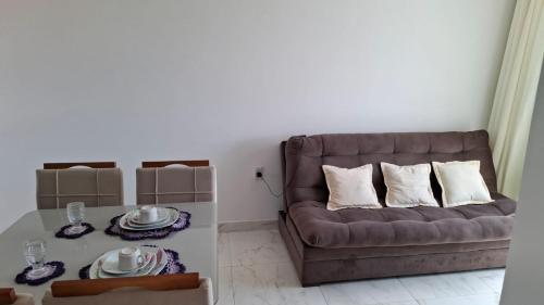 a living room with a couch and a table at Apartamento em Jacumã in Conde