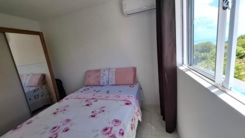 a small bedroom with a bed and a window at Apartamento em Jacumã in Conde