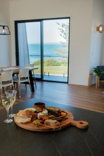 a plate of food on a table with a glass of wine at Fairy Wren in Kingscote
