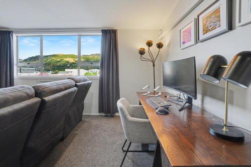 een kamer met een bureau, een computer en een bank bij The Upper Rooms in Nelson