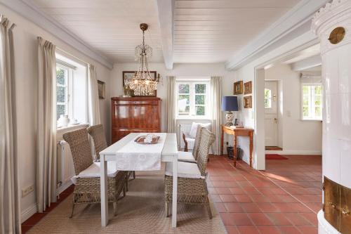 una sala da pranzo con tavolo e sedie bianchi di Sanfte Brise 1- links a Oevenum