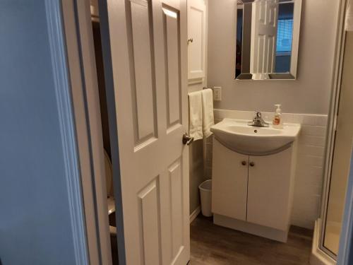 een witte badkamer met een wastafel en een spiegel bij Apartment In Saskatoon in Saskatoon