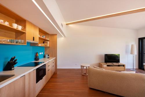 a kitchen and living room with a couch and a table at Charlie's Hideaway in Vincentia