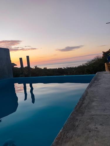 a swimming pool with the sunset in the background at Hotel Quinto Sol in Mazunte