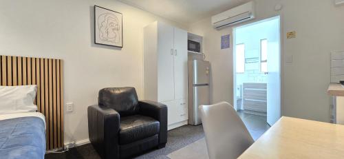 una camera da letto con una sedia, un letto e un tavolo di Motel 22 a Lower Hutt