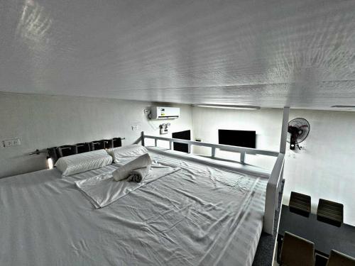 un grande letto bianco in una stanza con televisore di M&R Properties Philippines Lots 20 & 21 Family & Group Transient Homes Bella Vita Bangad Cabanatuan City NE 3100 a Bangad