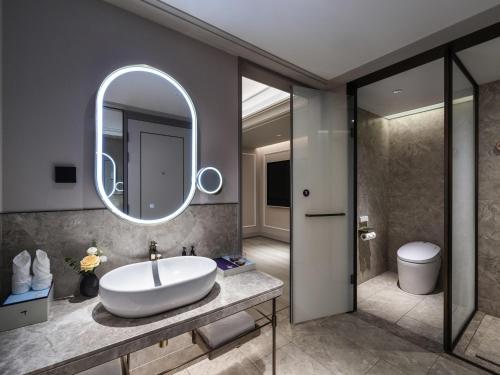 ein Badezimmer mit Waschbecken und Spiegel in der Unterkunft Mercure Shanghai Jinqiao in Shanghai