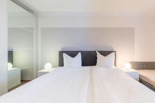 een slaapkamer met een wit bed en 2 witte kussens bij Ferienwohnung Erika in Dassow