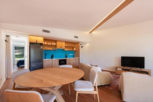 a kitchen and living room with a table and chairs at Charlie's Hideaway in Vincentia