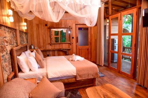 a bedroom with a bed in a room with wooden walls at Eco Cabins Hideaway Ella in Ella