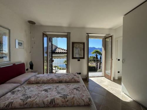 ein Schlafzimmer mit Bett und Blick auf einen Balkon in der Unterkunft Villa with Panoramic Views in Oggebbio
