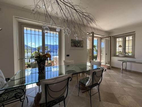 ein Esszimmer mit Glastisch und Stühlen in der Unterkunft Villa with Panoramic Views in Oggebbio