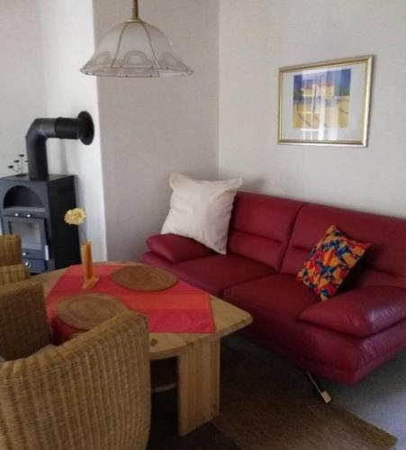 a living room with a red couch and a table at Am Hegehof - ABC181 in Lübstorf