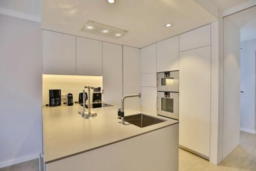 a kitchen with white cabinets and a sink at City Marina, CM22a in Cuxhaven