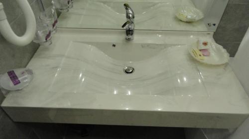 a white sink with a faucet in a bathroom at Relax Comfort Suites Hotel in Bucharest