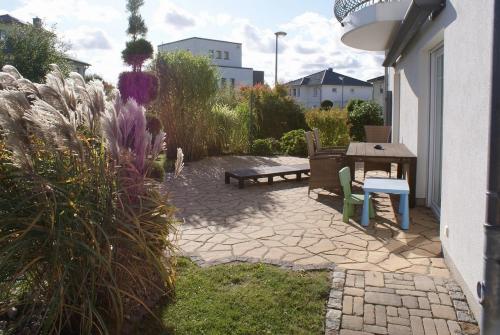 a patio with a bench and a table and flowers at Stadthaus Lübsche Burg - ABC326 in Wismar
