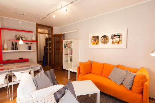- un salon avec un canapé orange et une table dans l'établissement Toti Apartment, à Udine