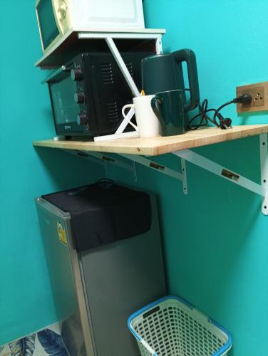 een kamer met een plank waarop een magnetron en een computer staan bij BP family room 4 in Ko Mak