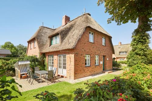 una vecchia casa in mattoni con tetto di paglia di Haus Kastanie a Boldixum