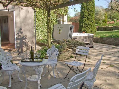 een terras met een tafel en stoelen en een barbecue bij Purcombe Farmhouse - 28458 in Whitchurch Canonicorum