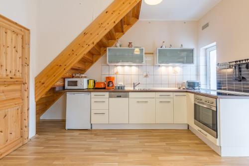 a kitchen with white appliances and a wooden staircase at Ferienhaus Klütz in Klütz