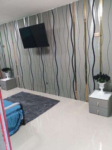 een kamer met een flatscreen-tv aan de muur bij BP family room 4 in Ko Mak