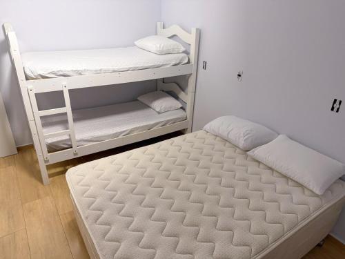 a bedroom with a bunk bed and a mattress at Recanto perto do mar com Jacuzzi in Camboriú