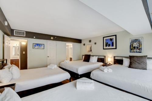 a room with three beds with white sheets at Stay Together Suites - Condominium Sleeps 14 with Iconic Vegas Views, Attached to The Cosmopolitan, NO RESORT FEES in Las Vegas