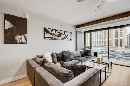 a living room with a large couch and a large window at Stay Together Suites - Condominium Sleeps 14 with Iconic Vegas Views, Attached to The Cosmopolitan, NO RESORT FEES in Las Vegas