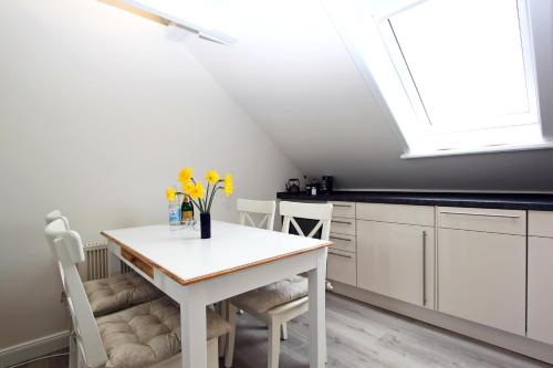 eine Küche mit einem weißen Tisch und einem Dachfenster in der Unterkunft Syltrose in Hörnum